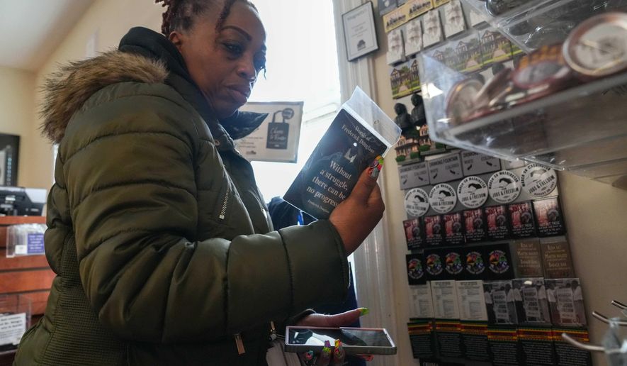 Keisha Burse looks at items for sale at Martin Luther King Jr. National Historical Park, Tuesday, Dec. 9, 2025, in Atlanta. (AP Photo/Megan Varner)