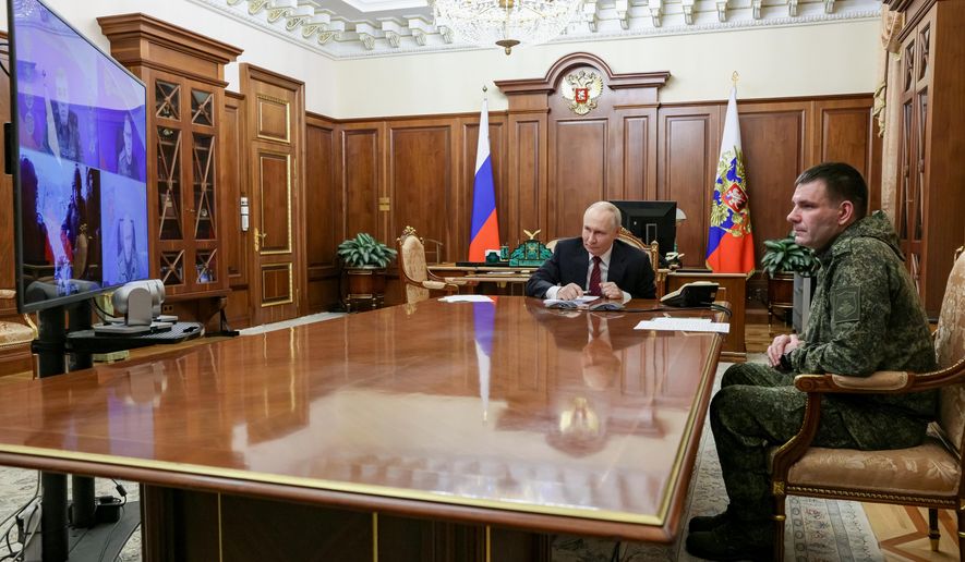 Russian President Vladimir Putin, center, holds a call with military leaders on the Ukraine battlefield situation together with Denis Pirogov, right, a Russian army brigade commander, at the Kremlin in Moscow, on Thursday, Dec. 11, 2025. (Gavriil Grigorov, Sputnik, Kremlin Pool Photo via AP)