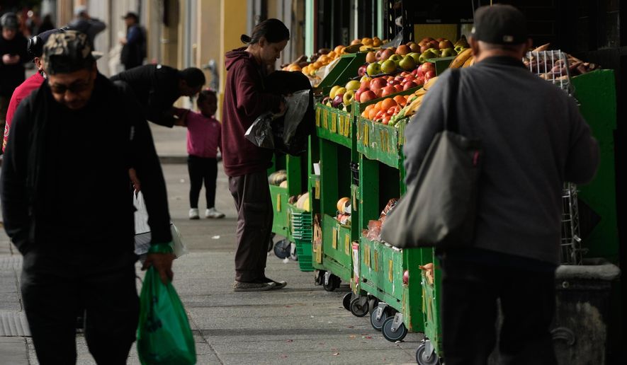 A person shops for produce at a market in San Francisco on Saturday, Nov. 15, 2025. (AP Photo/Jeff Chiu)