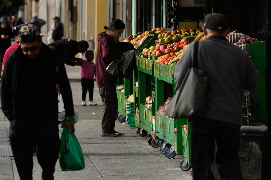 A person shops for produce at a market in San Francisco on Saturday, Nov. 15, 2025. (AP Photo/Jeff Chiu)