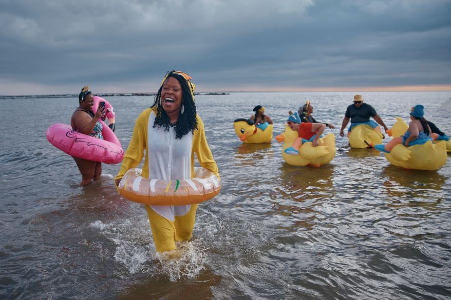 Revelers in costumes enter the cold water during the annual Polar Bear Plunge on New Year's Day, Jan. 1, 2025, in New York. (AP Photo/Andres Kudacki, File)