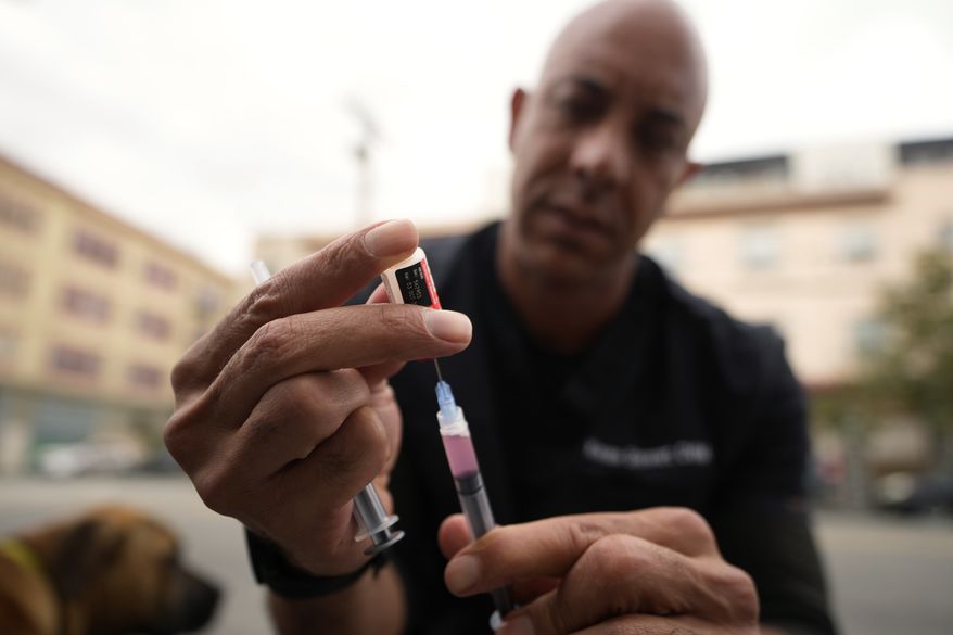 A doctor prepares a rabies vaccine. (AP Photo/Damian Dovarganes)