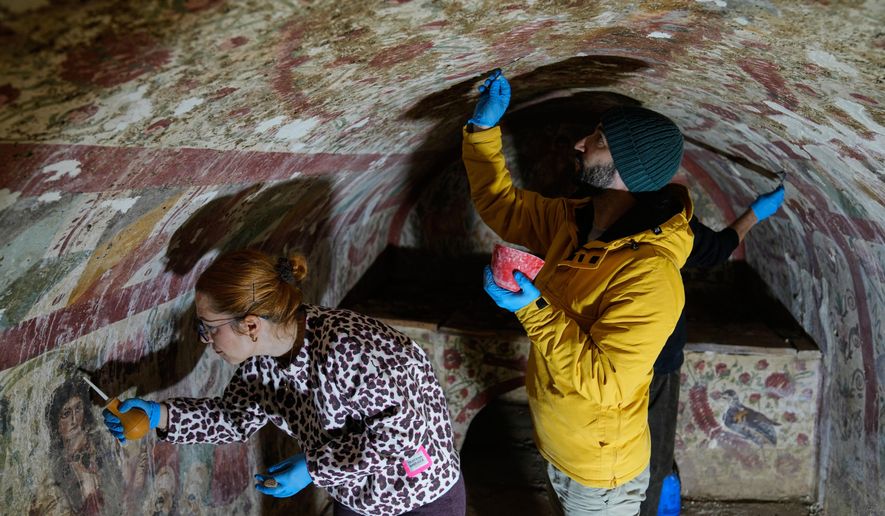 Archaeologists clean and restore frescoes inside a 3rd-century tomb where a rare early Christian depiction of Jesus as the "Good Shepherd" was discovered, in Iznik, Turkey, Friday, Dec. 12, 2025. (AP Photo/Khalil Hamra)