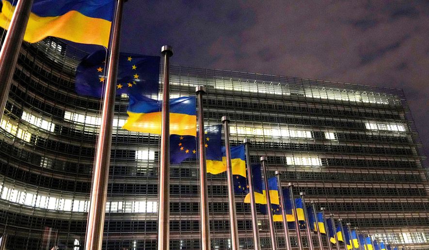 The European Union and Ukrainian flags flap in the wind to mark the third anniversary of Russia's full-scale invasion of Ukraine outside EU headquarters in Brussels, Feb. 24, 2025. (AP Photo/Virginia Mayo, File)