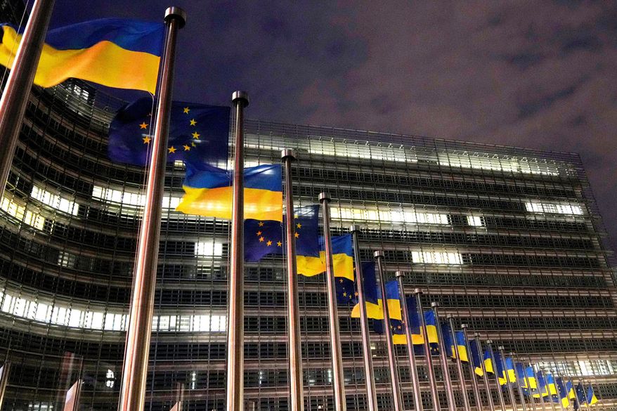 The European Union and Ukrainian flags flap in the wind to mark the third anniversary of Russia's full-scale invasion of Ukraine outside EU headquarters in Brussels, Feb. 24, 2025. (AP Photo/Virginia Mayo, File)