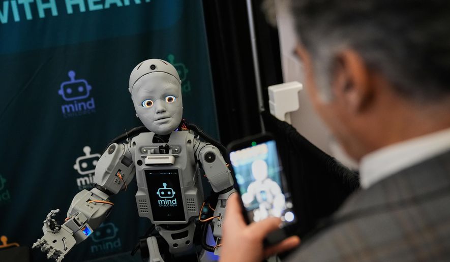 A man records a humanoid robot inside the exhibition room at the Humanoids Summit, Thursday, Dec. 11, 2025, in Mountain View, Calif. (AP Photo/Godofredo A. Vásquez)