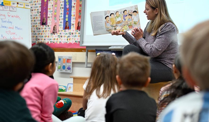 Kindergarten teacher Christin Labriola reads the book "Dumpling Soup" to her class, incorporating Asian American and Pacific Islander subjects in her class at Webster Hill Elementary School in West Hartford, Conn., on Dec. 2, 2025. (AP Photo/Jessica Hill)