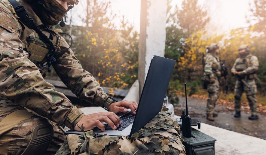 A soldier engineer uses a laptop to transmit aerial photos and data from a drone to military headquarters. File photo credit: Parilov via Shutterstock.