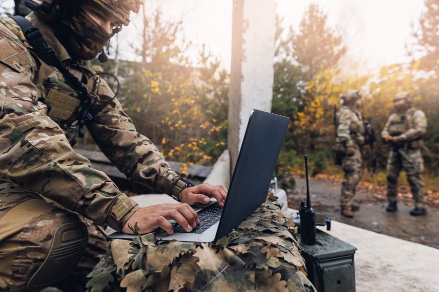A soldier engineer uses a laptop to transmit aerial photos and data from a drone to military headquarters. File photo credit: Parilov via Shutterstock.