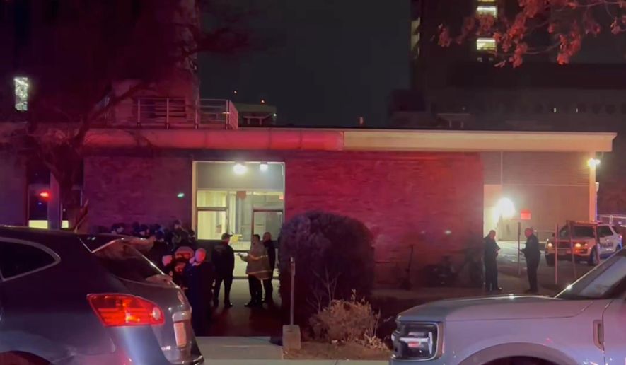 In this image from video, law enforcement officials gather outside the Brown University campus in Providence, R.I., on Saturday, Dec. 13, 2025. (AP Photo/Kimberlee Kruesi)