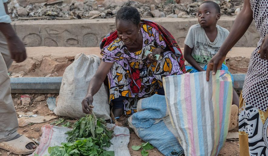 People buy and sell as residents return to their homes in Uvira, Democratic Republic of Congo, Saturday, Dec. 13, 2025. (AP Photo/Moses Sawasawa)