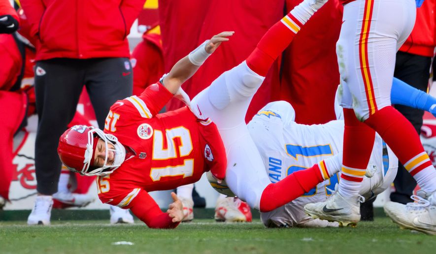 Kansas City Chiefs quarterback Patrick Mahomes (15) is injured after being tackled by Los Angeles Chargers defensive tackle Da'Shawn Hand (91) during the second half of an NFL football game, Sunday, Dec. 14, 2025 in Kansas City, Mo. (AP Photo/Reed Hoffmann)
