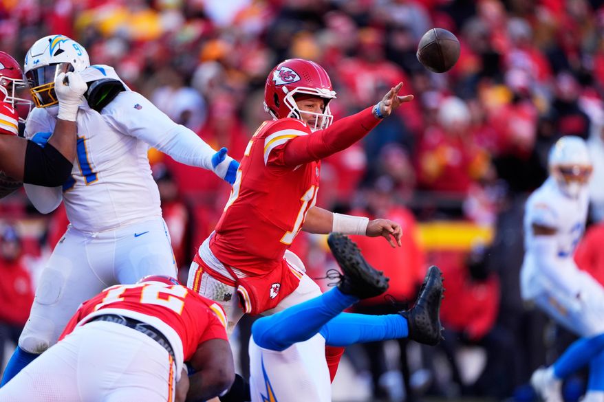 Kansas City Chiefs quarterback Patrick Mahomes (15) gets rid of the ball during the second half of an NFL football game against the Los Angeles Chargers Sunday, Dec. 14, 2025, in Kansas City, Mo. (AP Photo/Charlie Riedel)