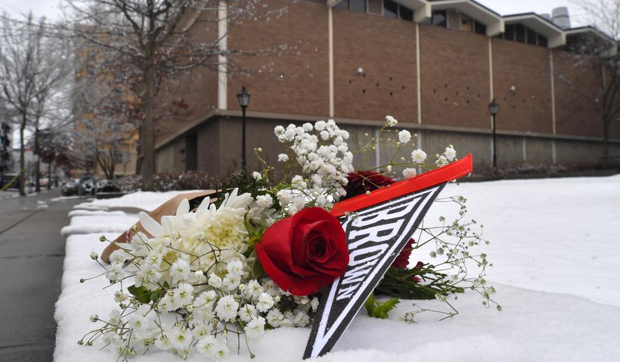 A bouquet of flowers rests on snow, Sunday, Dec. 14, 2025, on the campus of Brown University not far from where a shooting took place, in Providence, R.I. (AP Photo/Steven Senne)