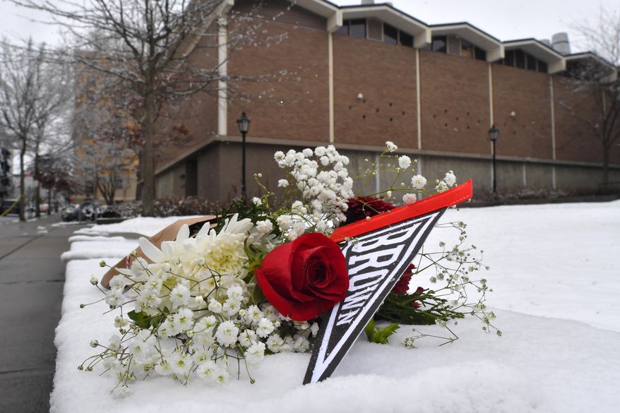 A bouquet of flowers rests on snow, Sunday, Dec. 14, 2025, on the campus of Brown University not far from where a shooting took place, in Providence, R.I. (AP Photo/Steven Senne)
