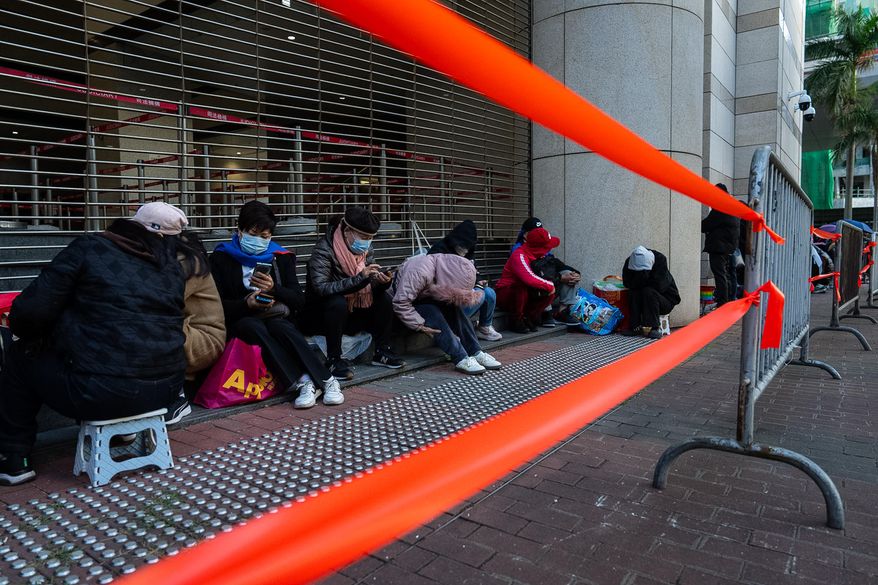 People wait to enter the West Kowloon Magistrates' Courts ahead of the verdict for Hong Kong activist publisher Jimmy Lai's national security trial, in Hong Kong, Monday, Dec. 15, 2025. (AP Photo/Chan Long Hei)