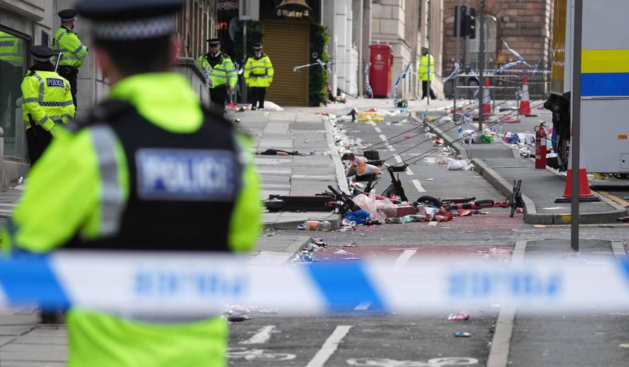 FILE - Police guards the site where a 53-year-old British man plowed a minivan into a crowd of Liverpool soccer fans who were celebrating the city's Premier League championship Monday, injuring more than 45 people in Liverpool, England, Tuesday, May 27, 2025.(AP Photo/Jon Super, File)