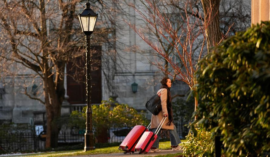A Brown University student leaves campus, Tuesday, Dec. 16, 2025, after all classes, exams and papers were canceled for the rest of the Fall 2025 semester following the school shooting, in Providence, R.I. (AP Photo/Robert F. Bukaty)