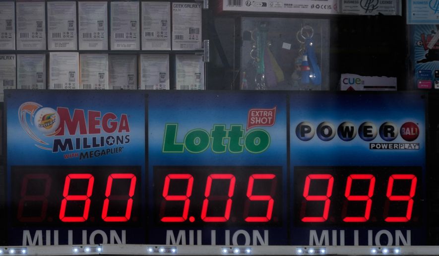 Jackpot payouts for the Mega Millions, Lotto, and Powerball are seen in a convenience store window in Prospect Height, Ill., Monday, Dec. 15, 2025. (AP Photo/Nam Y. Huh)