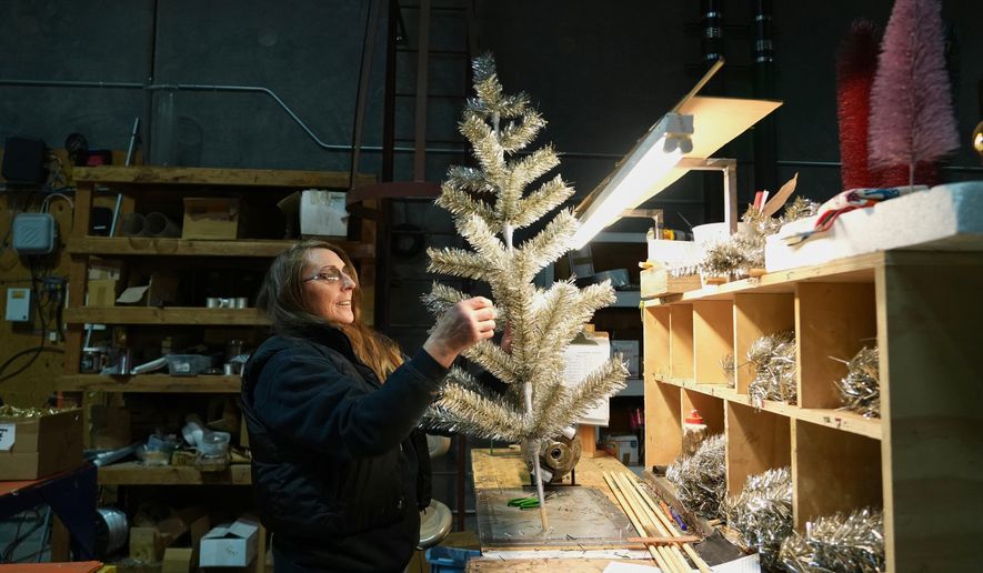 Melissa Webb assembles an artificial Christmas tree at Lee Display's warehouse, in Fairfield, Calif., Tuesday, Dec. 9, 2025. (AP Photo/Terry Chea)