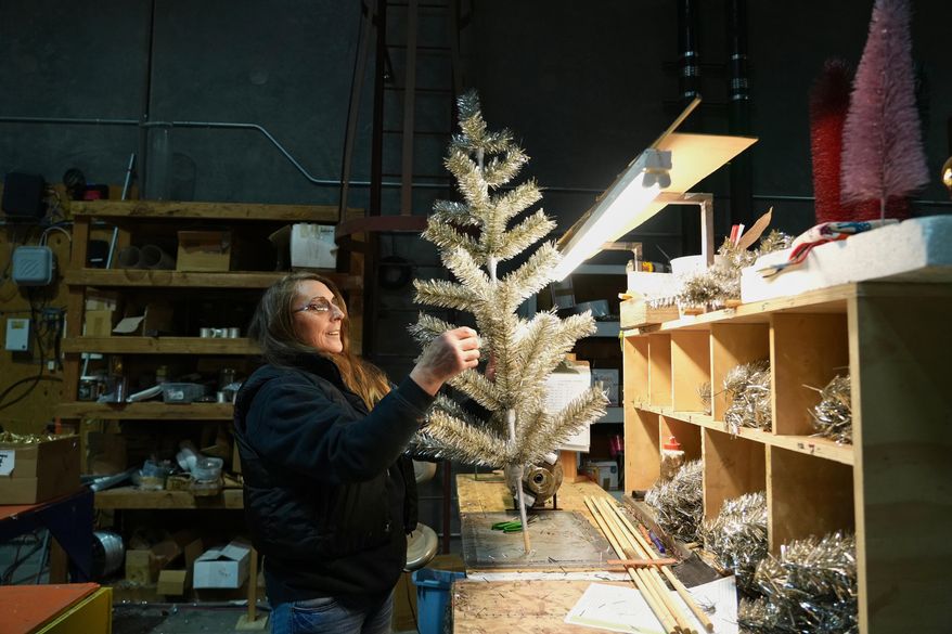 Melissa Webb assembles an artificial Christmas tree at Lee Display's warehouse, in Fairfield, Calif., Tuesday, Dec. 9, 2025. (AP Photo/Terry Chea)