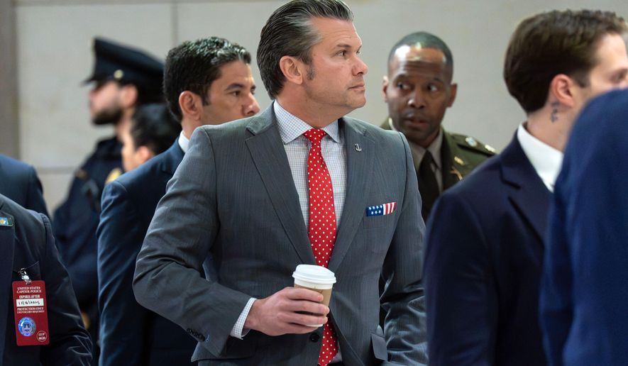 Defense Secretary Pete Hegseth walks to the auditorium to brief members of congress on military strikes near Venezuela at the Capitol, Tuesday, Dec. 16, 2025, in Washington. (AP Photo/Jose Luis Magana)