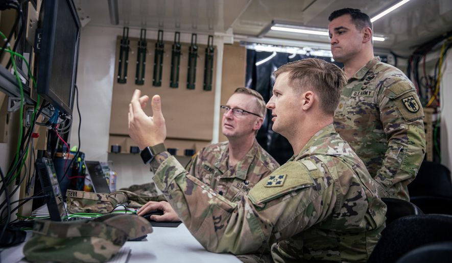 Sgt. 1st Class Demetrius Milczakowskyj (center), a senior fire control non-commissioned officer, assigned to Headquarters and Headquarters Battalion, 4th Infantry Division Artillery, 4th Infantry Division, briefs Lt. Col. David Graves (left), commander of 3rd Battalion, 157th Field Artillery Regiment, Colorado Army National Guard, and Maj. Ryan Hill (right), deputy commander of 3rd Battalion, 157th Field Artillery Regiment, Colorado Army National Guard on the functions and advantages of the Artillery Execution Suite (AXS) system during Ivy Sting III, December 9, 2025, Fort Carson, Colorado. Throughout Ivy Sting III, the displaced nodal construct showed how the division worked from different environments while maintaining effective communication on the move, highlighting how each node blended into the terrain as digital graphics demonstrated the decentralized command post concept across overseas locations. (U.S. Army photo by Pfc. Thomas Nguyen)