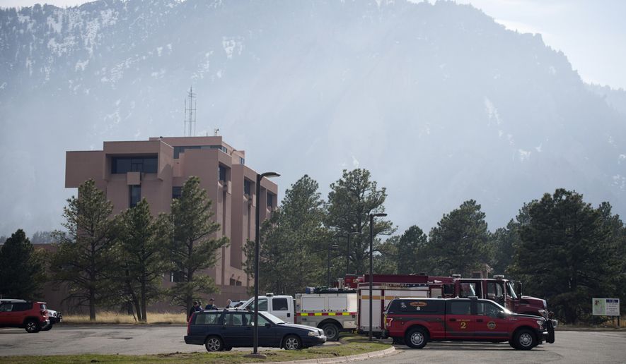 Firefighters' vehicles sit as a wildfire burns near the National Center for Atmospheric Research, Sunday, March 27, 2022, in Boulder, Colo. The fire, which started Saturday, is 35 percent contained and most evacuation orders have been lifted for the residents of nearby housing developments in the south end of Boulder. (AP Photo/David Zalubowski) **FILE**