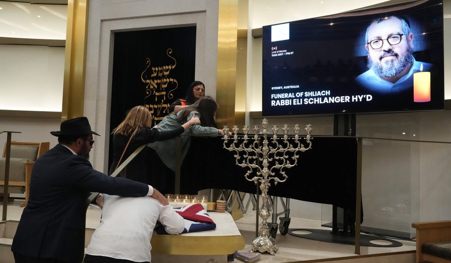 Family react at the coffin of Rabbi Eli Schlanger, a victim in the Bondi Beach mass shooting, during his funeral at a synagogue in Bondi on Wednesday, Dec. 17, 2025, in Sydney, Australia. (AP Photo/Mark Baker, Pool)