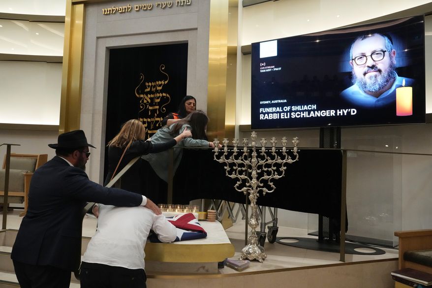 Family react at the coffin of Rabbi Eli Schlanger, a victim in the Bondi Beach mass shooting, during his funeral at a synagogue in Bondi on Wednesday, Dec. 17, 2025, in Sydney, Australia. (AP Photo/Mark Baker, Pool)