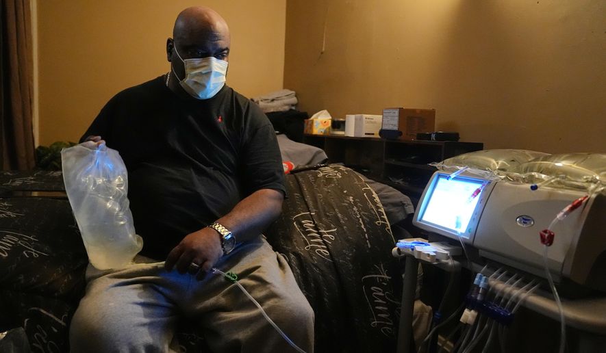 Ahmad Collins, a city government worker and former Penn State linebacker, prepares for his nightly dialysis at his home in Harrisburg, Pa., Thursday, Dec. 11, 2025. (AP Photo/Matt Rourke)