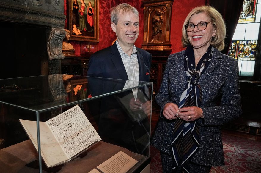 Skylark Artistic Director Matthew Guard and Christine Baranski are interviewed beside "A Christmas Carol In Prose; Being a Ghost Story of Christmas" by Charles Dickens, Dec. 1843," at The Morgan Library & Museum, in New York, Monday, Dec. 1, 2025. (AP Photo/Richard Drew)