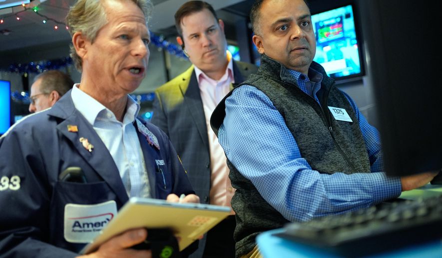 Dilip Patel, right, and Bobby Charmak, left, work on the floor at the New York Stock Exchange in New York, Wednesday, Dec. 10, 2025. (AP Photo/Seth Wenig)