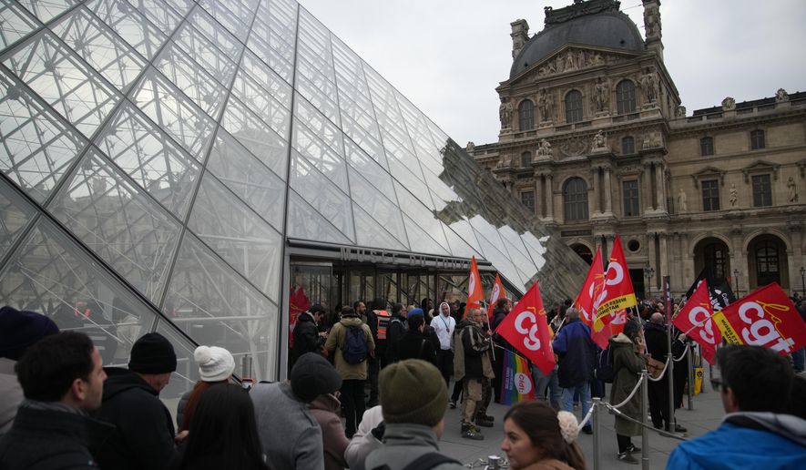 Unionists demonstrate at the entrance of the Louvre museum after employees have voted to extend a strike that has disrupted operations at the world's most visited museum, Wednesday, Dec. 17, 2025 in Paris. (AP Photo/Christophe Ena)