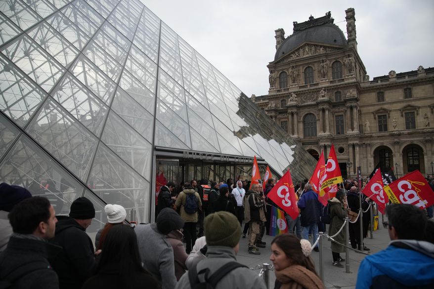 Unionists demonstrate at the entrance of the Louvre museum after employees have voted to extend a strike that has disrupted operations at the world's most visited museum, Wednesday, Dec. 17, 2025 in Paris. (AP Photo/Christophe Ena)