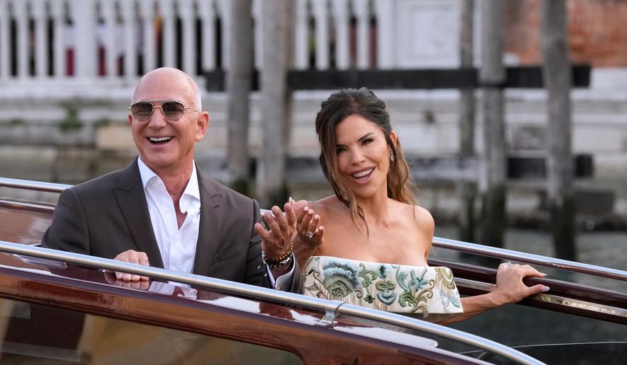FILE - Jeff Bezos, left, and Lauren Sanchez leave a hotel for their pre wedding reception, in Venice, Italy, Thursday, June 26, 2025. (AP Photo/Luca Bruno, File)