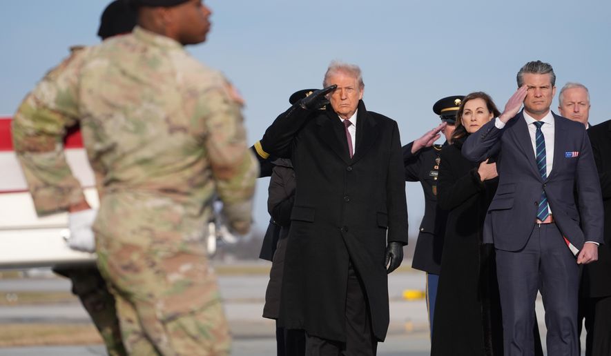 President Donald Trump and Defense Secretary Pete Hegseth salute as a Army carry teams moves the remains of Iowa National Guard soldier Sgt. William Nathaniel Howard, 29, of Marshalltown, Iowa, during a casualty return, Wednesday, Dec. 17, 2025, at Dover Air Force Base, Del. (AP Photo/Evan Vucci)