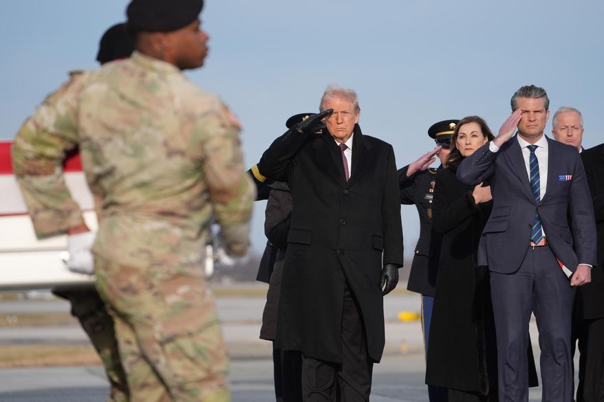 President Donald Trump and Defense Secretary Pete Hegseth salute as a Army carry teams moves the remains of Iowa National Guard soldier Sgt. William Nathaniel Howard, 29, of Marshalltown, Iowa, during a casualty return, Wednesday, Dec. 17, 2025, at Dover Air Force Base, Del. (AP Photo/Evan Vucci)