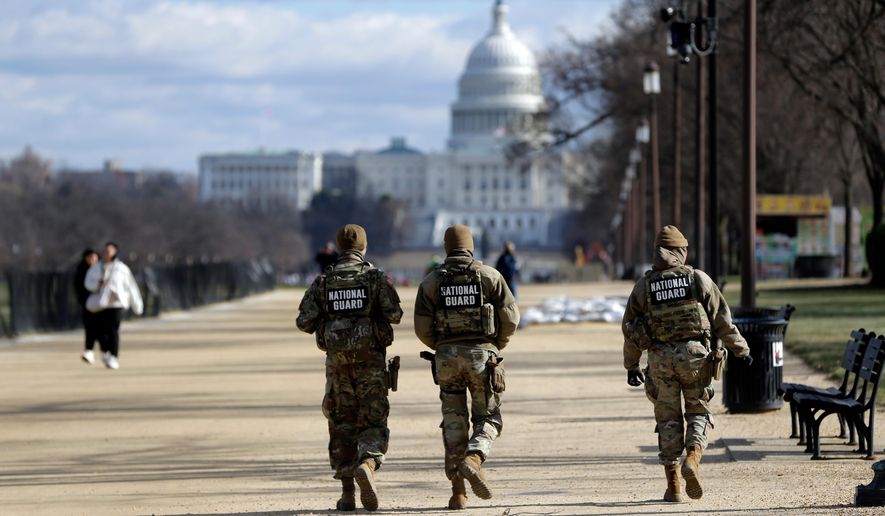 National Guard patrol on the National Mall near the Washington Capitol, Thursday, Dec. 11, 2025, in Washington. (AP Photo/Rahmat Gul)