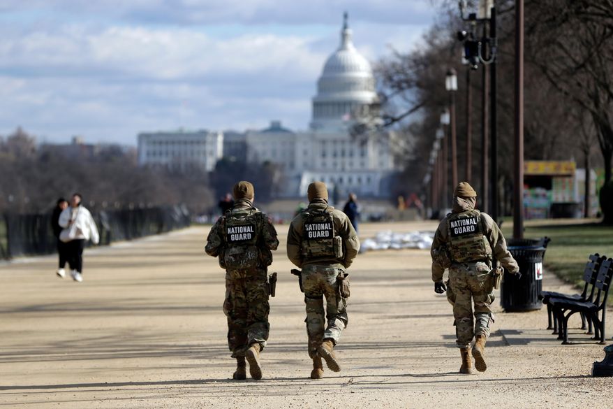 National Guard patrol on the National Mall near the Washington Capitol, Thursday, Dec. 11, 2025, in Washington. (AP Photo/Rahmat Gul)