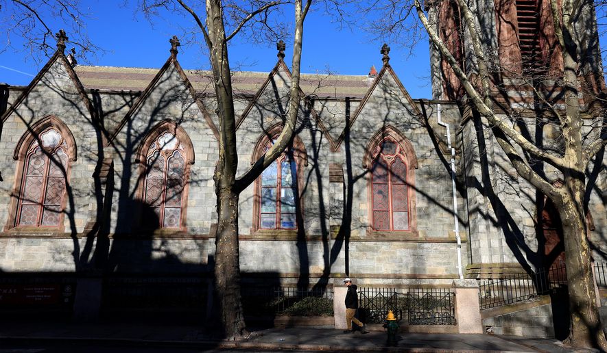 A Brown University student walks past a church on the Providence, RI, campus, Thursday, Dec. 18, 2025. (AP Photo/ Mark Stockwell)