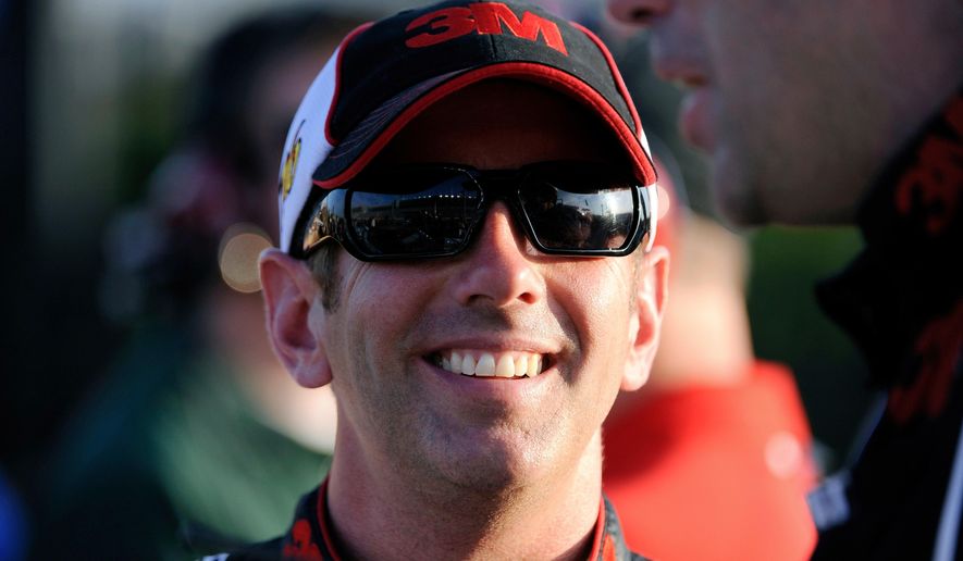 Greg Biffle smiles along pit row during qualifying for Sunday's NASCAR Sprint Cup Series auto race at Atlanta Motor Speedway, Friday, Aug. 31, 2012, in Hampton, Ga. (AP Photo/David Tulis, File) **FILE**