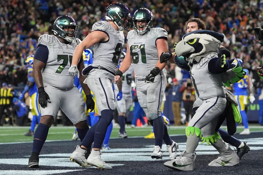 Seattle Seahawks tight end Eric Saubert, second from left, celebrates after making a two-point conversion during overtime in an NFL football game against the Los Angeles Rams, Thursday, Dec. 18, 2025, in Seattle. (AP Photo/Lindsey Wasson)