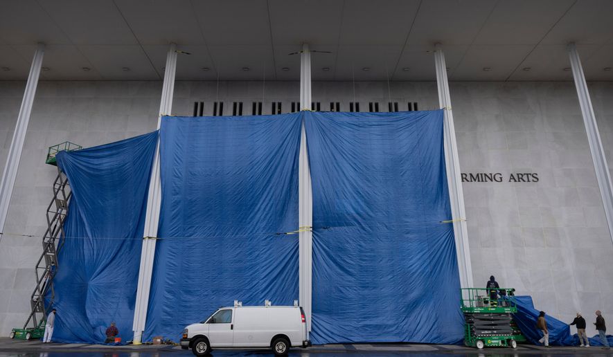 Tarps are installed in front of the sign on the Kennedy Center on Friday, Dec. 19, 2025, in Washington. (AP Photo/Mark Schiefelbein)