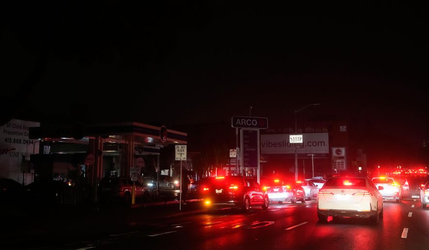 Cars wait at an intersection with no working traffic lights from power outages, in San Francisco, Saturday, Dec. 20, 2025. (AP Photo/Jeff Chiu)