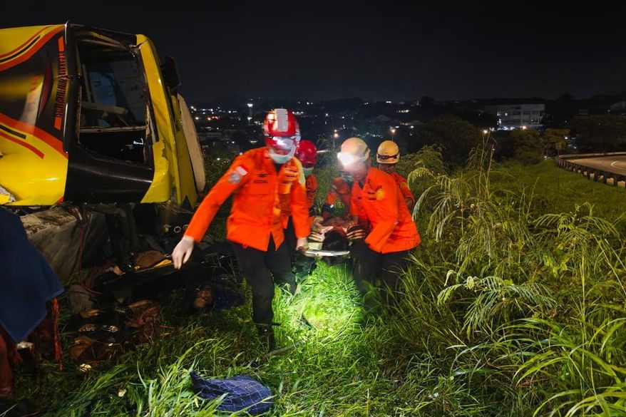 In this photo released by the Semarang Search and Rescue Office, rescuers carry a survivor of a deadly bus crash on a stretcher, in Semarang, Central Java, Indonesia, Monday, Dec. 22, 2025. (Semarang SAR Office via AP)