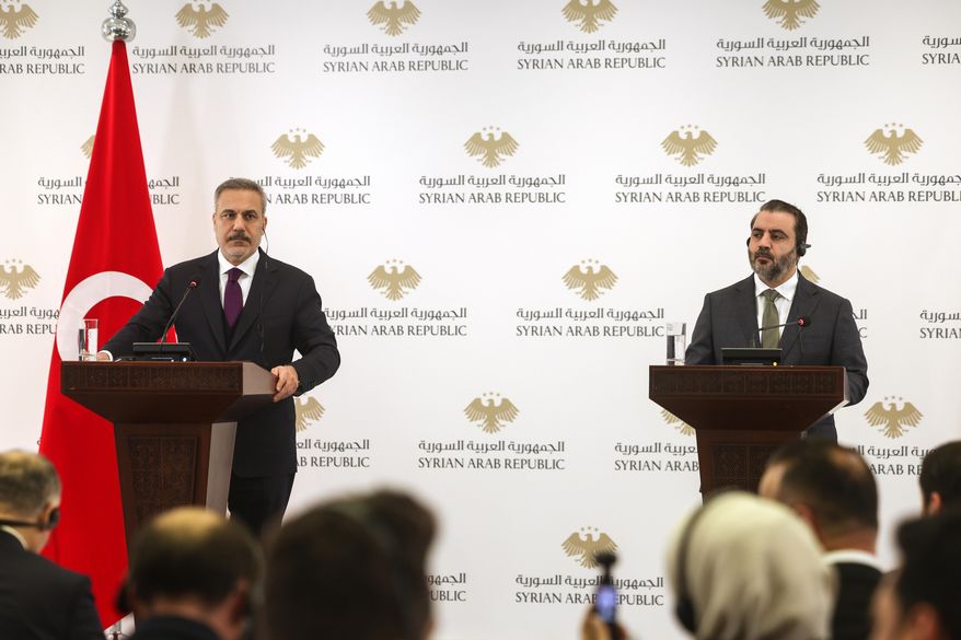 Turkish Foreign Minister Hakan Fidan, left, and his Syrian counterpart Asaad al-Shibani hold a joint news conference after their meeting in Damascus, Syria, Monday, Dec. 22, 2025. (AP Photo/Ghaith Alsayed)