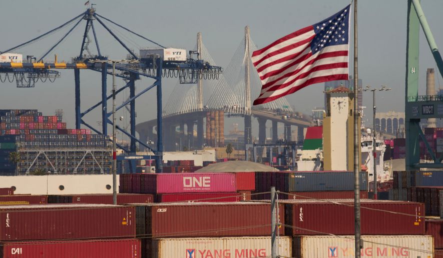 FILE - Containers with Yang Ming Marine Transport Corporation, a Taiwanese container shipping company, are stacked up at the Port of Los Angeles with the the Long Beach International Gateway Bridge seen in the background on Wednesday, April 9, 2025 in Los Angeles. (AP Photo/Damian Dovarganes, File)