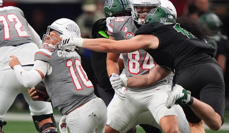 UNLV quarterback Anthony Colandrea (10) is grabbed by Ohio defensive lineman Evan Herrmann (11) during the second half of the Frisco Bowl NCAA college football game Tuesday, Dec. 23, 2025, in Frisco, Texas. (AP Photo/LM Otero)