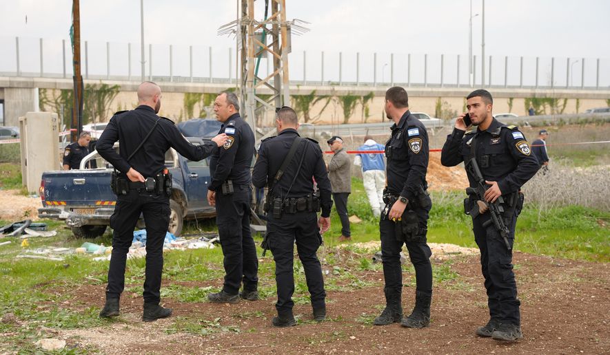 In this photo released by Israel Police on Friday, Dec. 26, 2025, Israeli police officers work on the site where a vehicle was used, according to the authorities, during a suspected ramming and stabbing attack in Afula, northern Israel. (Israel Police via AP)